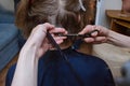 Women`s haircut at home. Hairdresser cuts a girl at home.