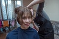 Women`s haircut at home. Hairdresser cuts a girl at home.