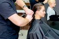 Young woman receiving haircut by male hairdresser Royalty Free Stock Photo