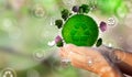 WomenÃÂ´s hand with ball of the green world in hand with solar panels, wind fans, trees and clouds. Businessman in energy Royalty Free Stock Photo