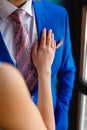 Women's hand on the chest of a man in an expensive suit. A close-up shot of a man in a blue suit while a womanÃ¯Â¿Â½s hand is resting