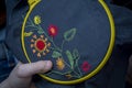 Women's hand embroidery in a hoop, a woman embroider a pattern on dark material. Close-up. The concept of needlework, hobby,