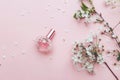 Women`s hand spray perfume. Flower arrangement. Flowers, fragrance, perfume on pink background Royalty Free Stock Photo