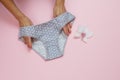 Women`s hands with beautiful panties on pink background