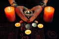 Women`s hands with bracelets and rings holding a burning candle in the dark. Royalty Free Stock Photo