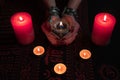 Women`s hands with bracelets and rings holding a burning candle in the dark. Royalty Free Stock Photo