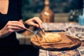 Women& x27;s hands cut khachapuri in Ajarian style with an egg on a wooden stand. Traditional Georgian pastries -