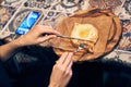 Women& x27;s hands cut khachapuri in Ajarian style with an egg on a wooden stand. Traditional Georgian pastries -