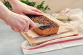 Women`s hands cut with a knife a piece of homemade vegan bread on a leaven of green buckwheat with flax seeds, sunflower on a Royalty Free Stock Photo