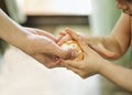 Women`s hands give a peeled boiled egg to a small child in the kitchen. A small child holds a boiled egg. The process of cleaning Royalty Free Stock Photo