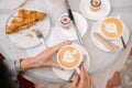 Women's hands hold a cup of coffee. There is a cut croissant on the table nearby and another cup of coffee Royalty Free Stock Photo