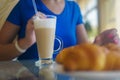 women's hands hold a glass of cappuccino. close-up