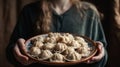 Women\'s hands hold a large plate with dumplings, generative AI tools