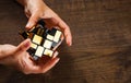 Women`s hands hold mirror magic cube on wooden background