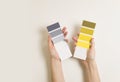 Women\'s hands hold swatches of the trendy colors of 2021 - yellow and gray. Selection of colors for design of clothes, interiors, Royalty Free Stock Photo