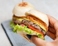 Women`s hands holding a healthy vegan burger made with bean meat