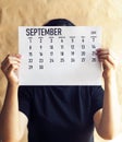 A woman holding simple September 2019 calendar