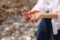 Women`s hands holds pebble stones on the palm on background of coastline, beach. selective focus Royalty Free Stock Photo