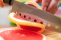 Women`s hands Housewives cut with a knife fresh grapefruit on the cutting Board of the kitchen table