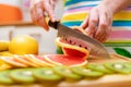 Women`s hands Housewives cut with a knife fresh grapefruit on th