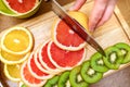 Women`s hands Housewives cut with a knife fresh grapefruit on th
