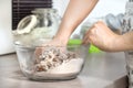 Women`s hands make dough for baked goods. The glass bowl with ingredients stands on the kitchen counter. Royalty Free Stock Photo