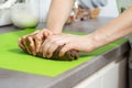 Women`s hands make a gingerbread dough for Christmas pastries. A glass bowl with ingredients stands on the kitchen counter. Royalty Free Stock Photo