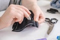 Women`s hands with a needle. Seamstress does running stitch a pattern pieces of clothing