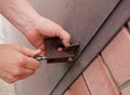 Women's hands open a rusty lock with keys. Lock on a metal door. Security Royalty Free Stock Photo