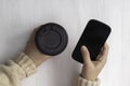 Women& x27;s hands with a paper cup of coffee and a phone, on a white wooden background. Royalty Free Stock Photo