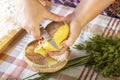 Women`s hands peel a raw potato with a kitchen knife.