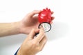 Women`s hands with a red heart and a blue stethoscope on a white background close-up. Heart in hand. Concept of cardiology. Royalty Free Stock Photo