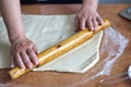 Women`s hands roll the dough on the kitchen table