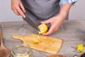 Women's hands slicing and extracting the seeds from a lemon with a chef knife on a cutting board Royalty Free Stock Photo