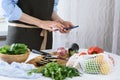 Women`s hands with smartphone in kitchen, cooking vegetables, cooking at home Royalty Free Stock Photo