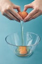 Women`s hands smashed a breakfast egg into a glass bowl. The yolk is inside the cup. Step by step an omelet. Step 2 Royalty Free Stock Photo