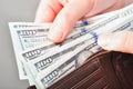 Women`s hands taking out hundred dollar bills from a wallet. No face. Close-up from a low angle Royalty Free Stock Photo