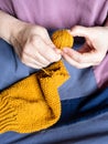 women's hands unravel knitted sweater close up