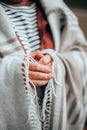 Women`s hands in a warm knitted blanket to keep warm in cold October weather in the forest or park