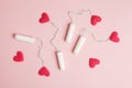 Women`s health care, cotton tampons with red hearts as blood drops on rose background, female critical days