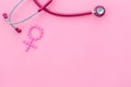 Women`s Health issues. Medical concept with Venus sign and stethoscope on pink background top-down copy space