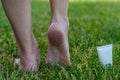 Women`s heels feet with dry skin and scaly with cream on grass Royalty Free Stock Photo