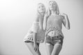 Women`s knitwear. Beauty fashion portrait. Twin sisters with long, blond hair posing on sunny day