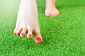 Women`s leg hesitantly steps on artificial grass Royalty Free Stock Photo