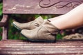 Women`s legs in leather boots. Woman resting in the park