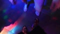 Women`s legs in silvery shoes are dancing on the dance floor in the disco bar. Light from safitov. 4k