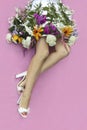 Women`s legs in a skirt of flowers and sandals. Royalty Free Stock Photo