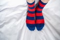 Women`s legs in socks colors alternating, side stand on white fabric floor. Royalty Free Stock Photo