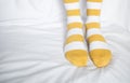 Women`s legs in socks colors alternating, side stand on white fabric floor. Royalty Free Stock Photo