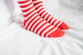 Women`s legs in socks colors alternating, side stand on white fabric floor. Royalty Free Stock Photo